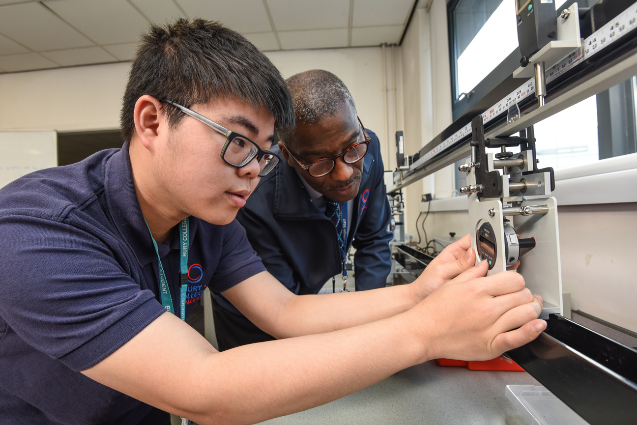 engineering student doing an experiment with support of the tutor