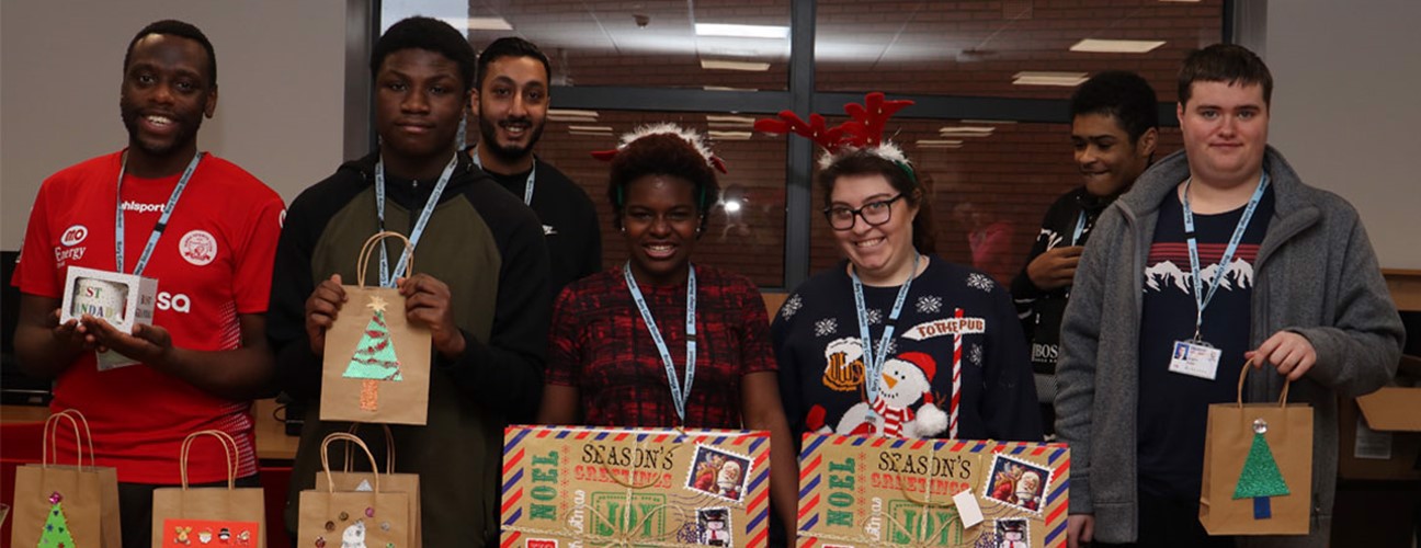 A group of Business Challenge students in front of wrapped Christmas gifts