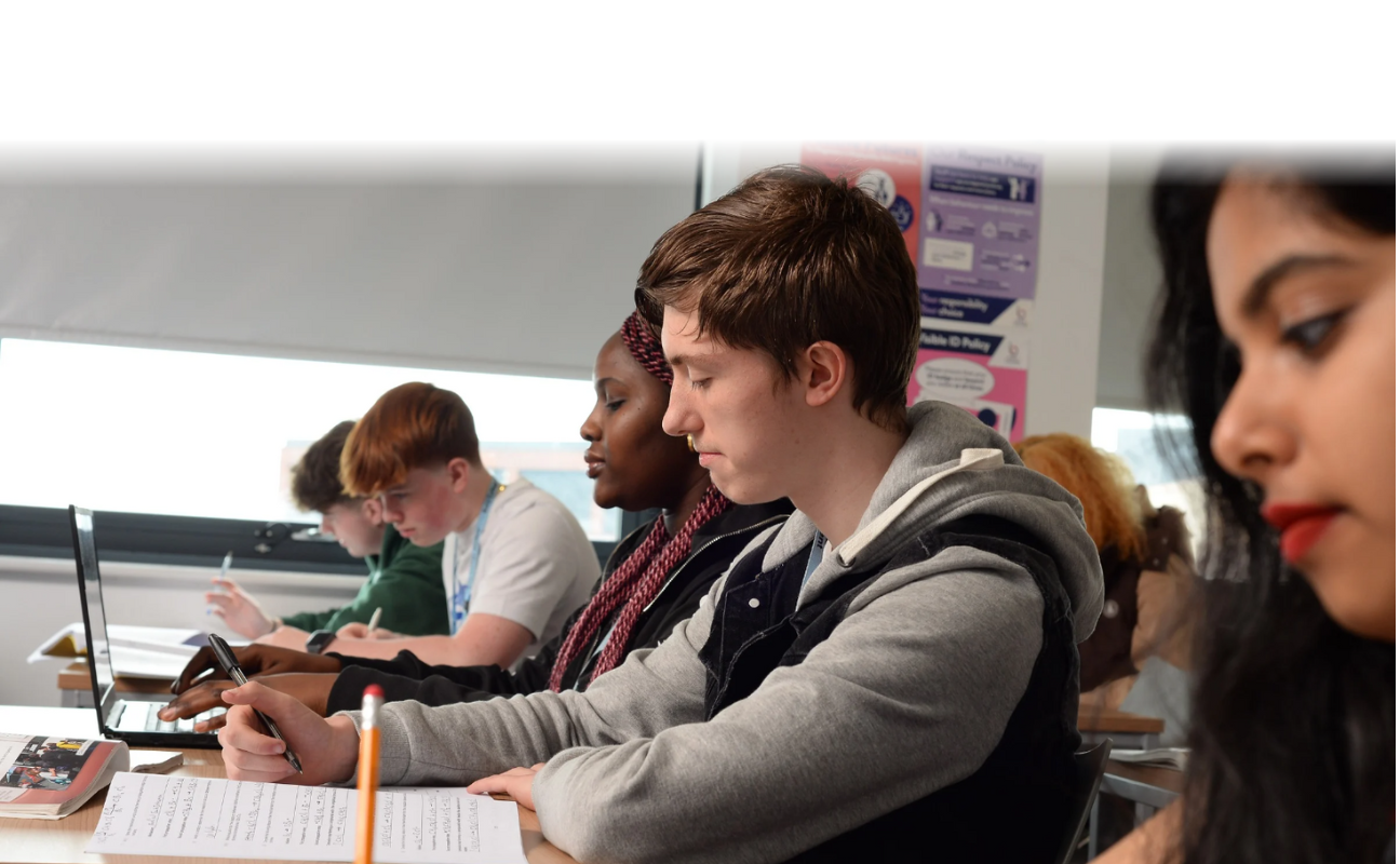 a row of students sat working in a classroom