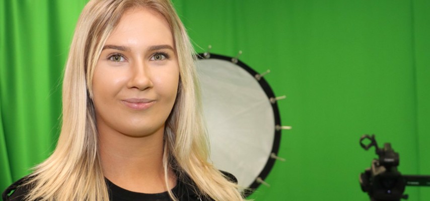 Former Creative Media Production student, Megan Barlow in front of a green screen studio
