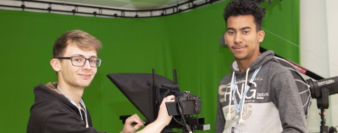 Two students in a green screen studio