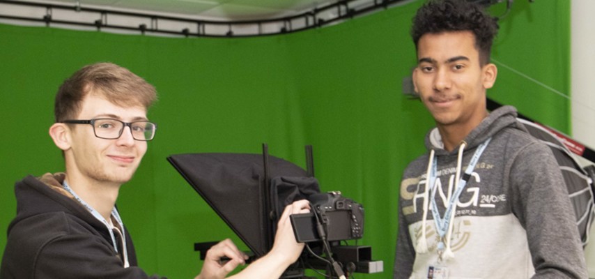 Two students in a green screen studio