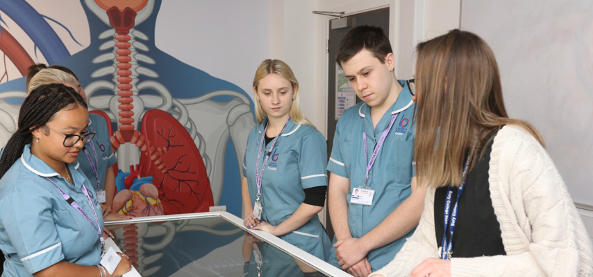 students and tutor stood around an anatomage table