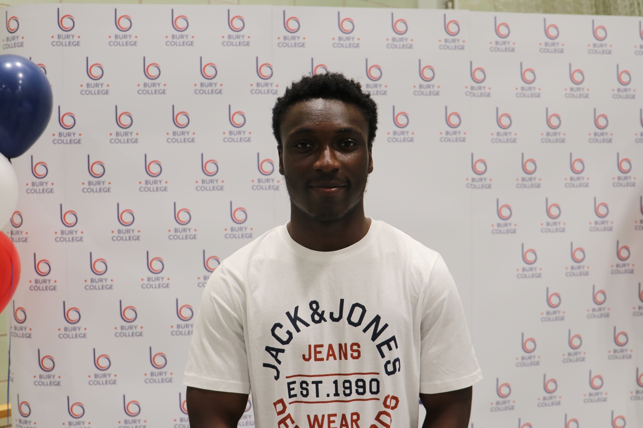 student smiling against Bury College backdrop