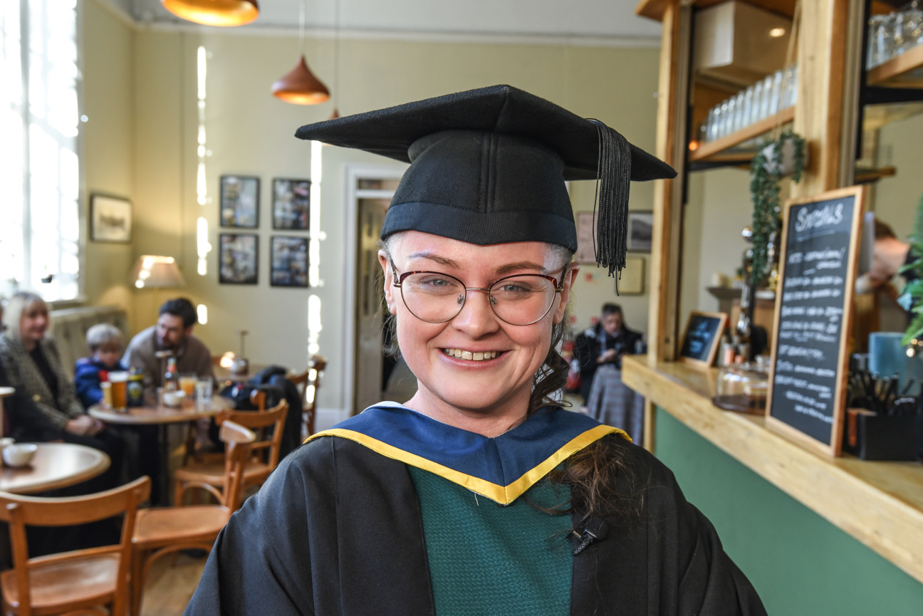 graduate smiling in their cap and gown