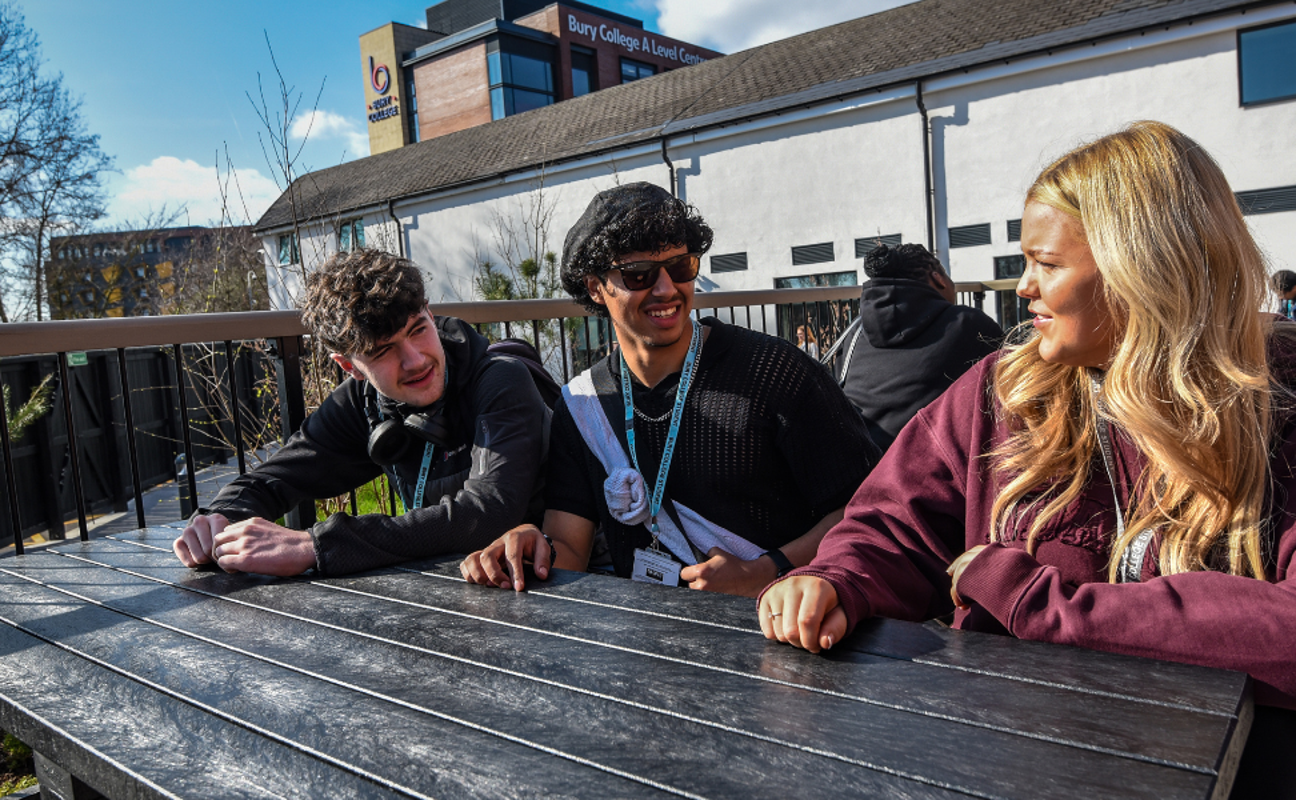 students sat outside laughing and smiling