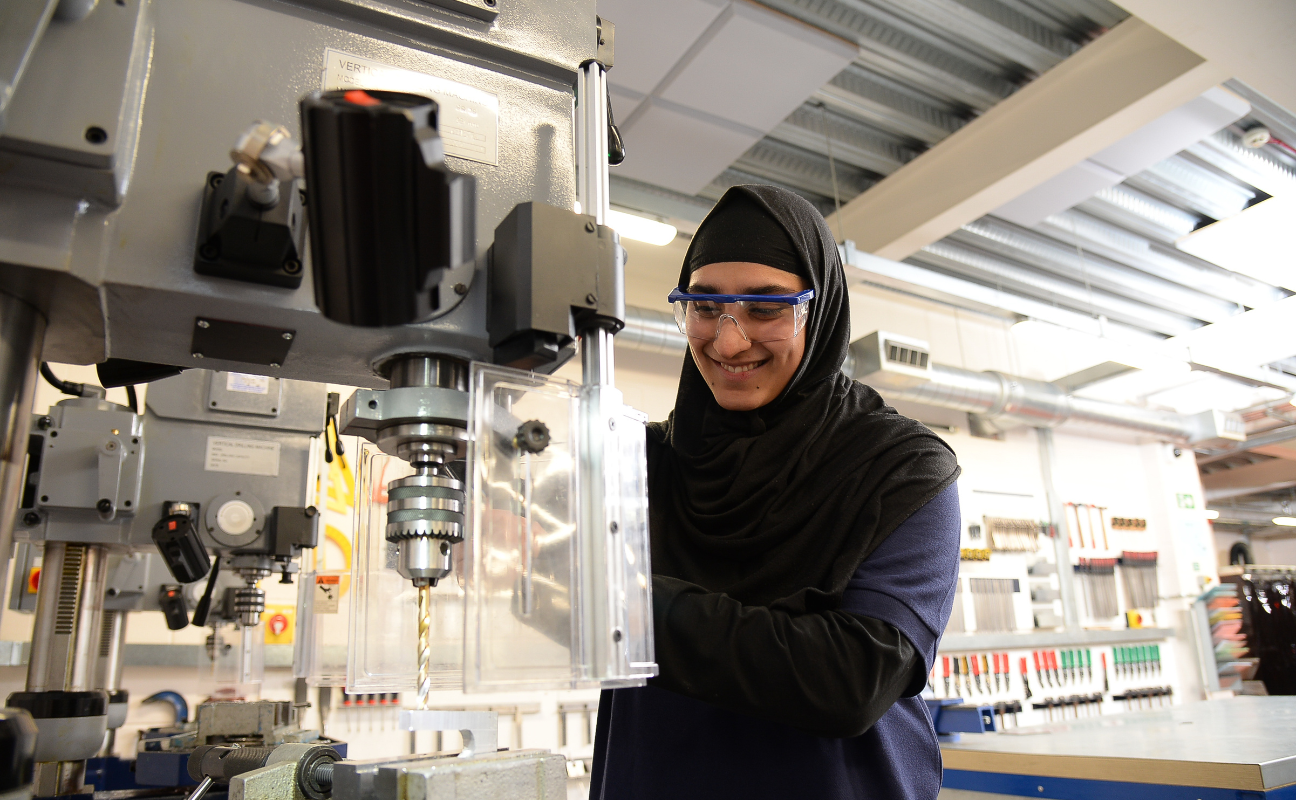 engineering student in the classroom working with a machine