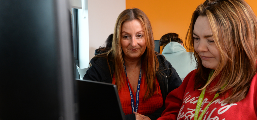 tutor and adult student sat at a computer