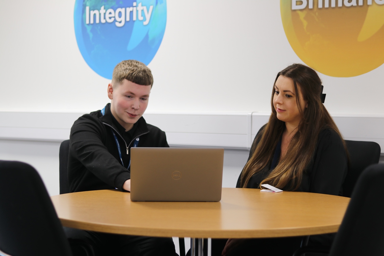 Student Carson Hamer sat with line manager looking at computer