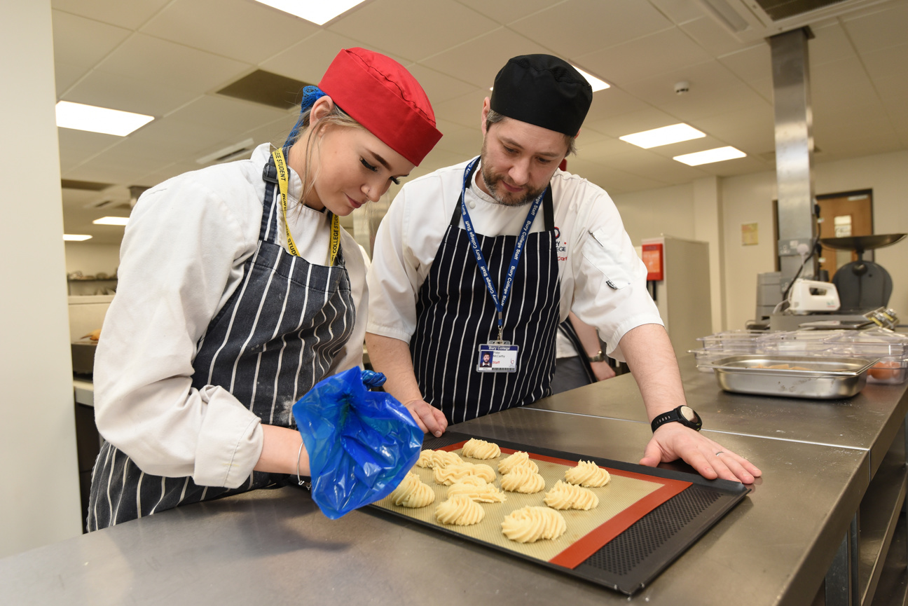 student in catering class with a catering tutor