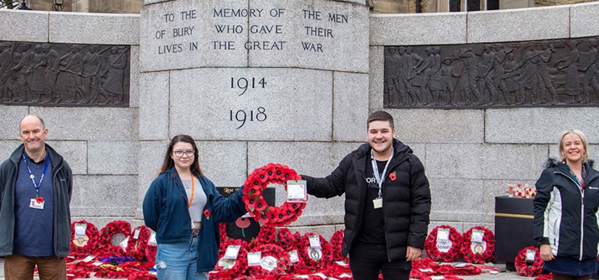 Students stood at the cenotaph in Bury with a Poppy wreath