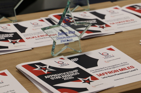 star shaped glass trophy on a table with certificates