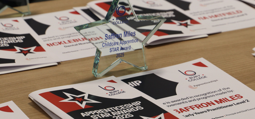 star shaped glass trophy on a table with certificates
