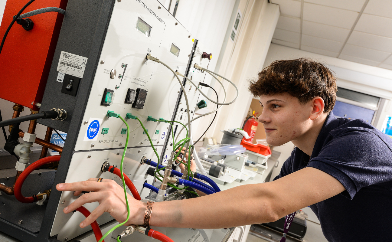 engineering student working on a board with lots of cables