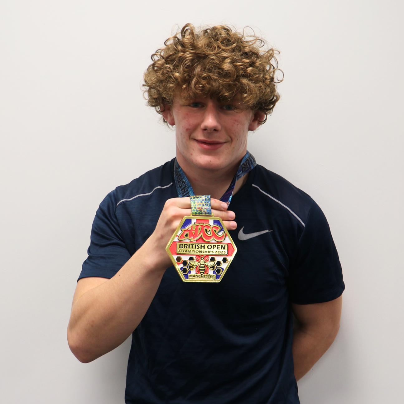 student holding golden medal from martial arts competition