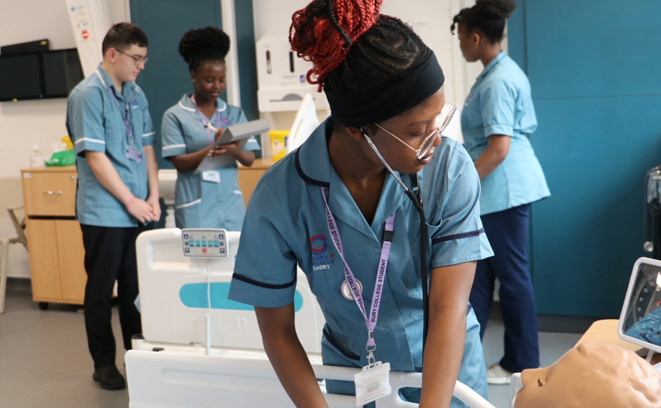 student in a mock ward treating test patient