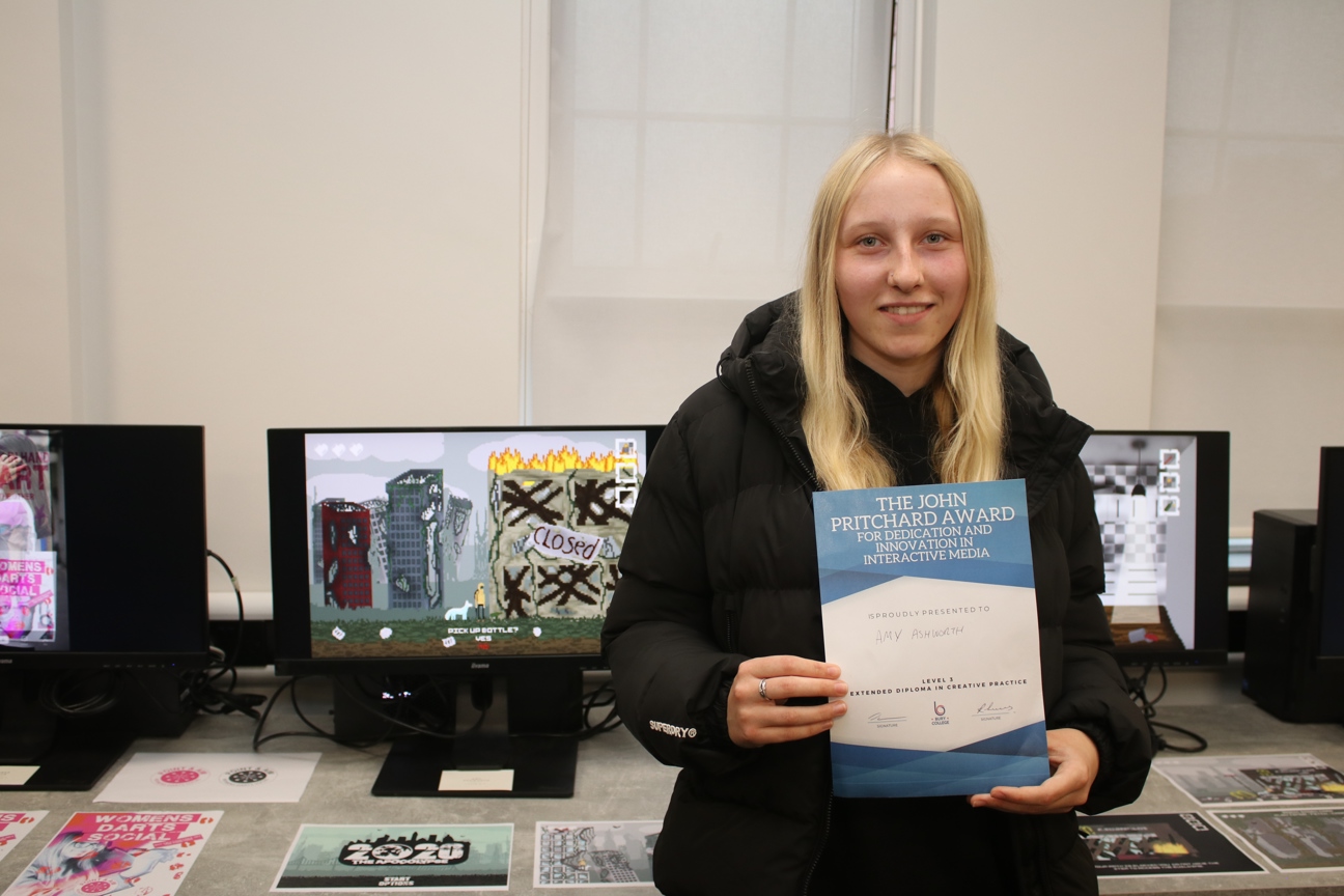 a games design student holding a certificate
