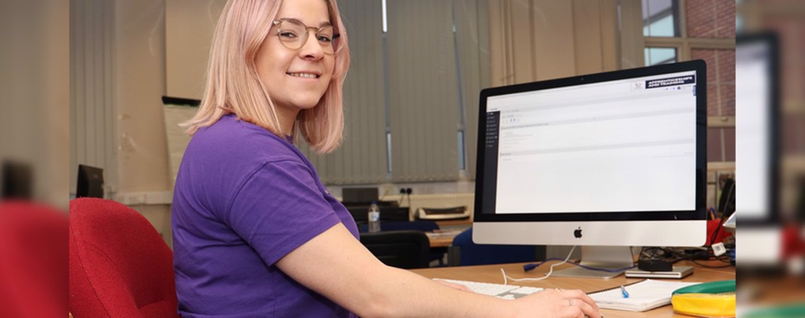Adult Care Worker Level 2 apprentice, Mollie Cooper sat at a computer