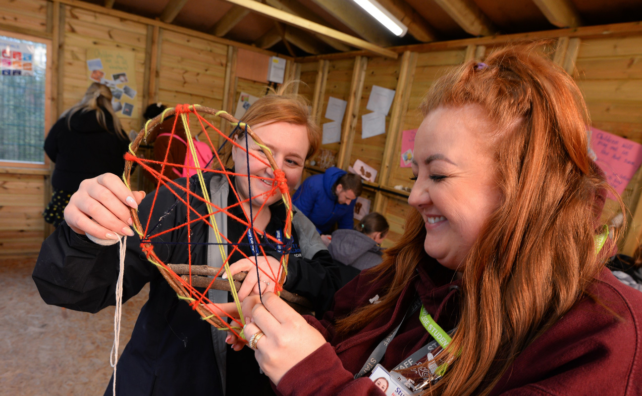 Adult students taking part in a forest school practical activity