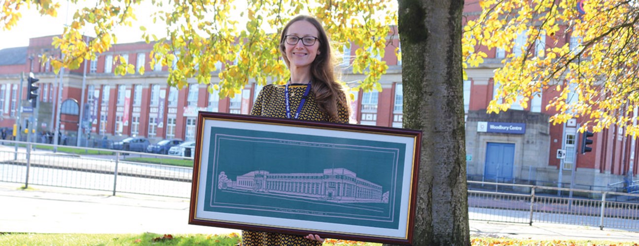 Student holding a tapestry