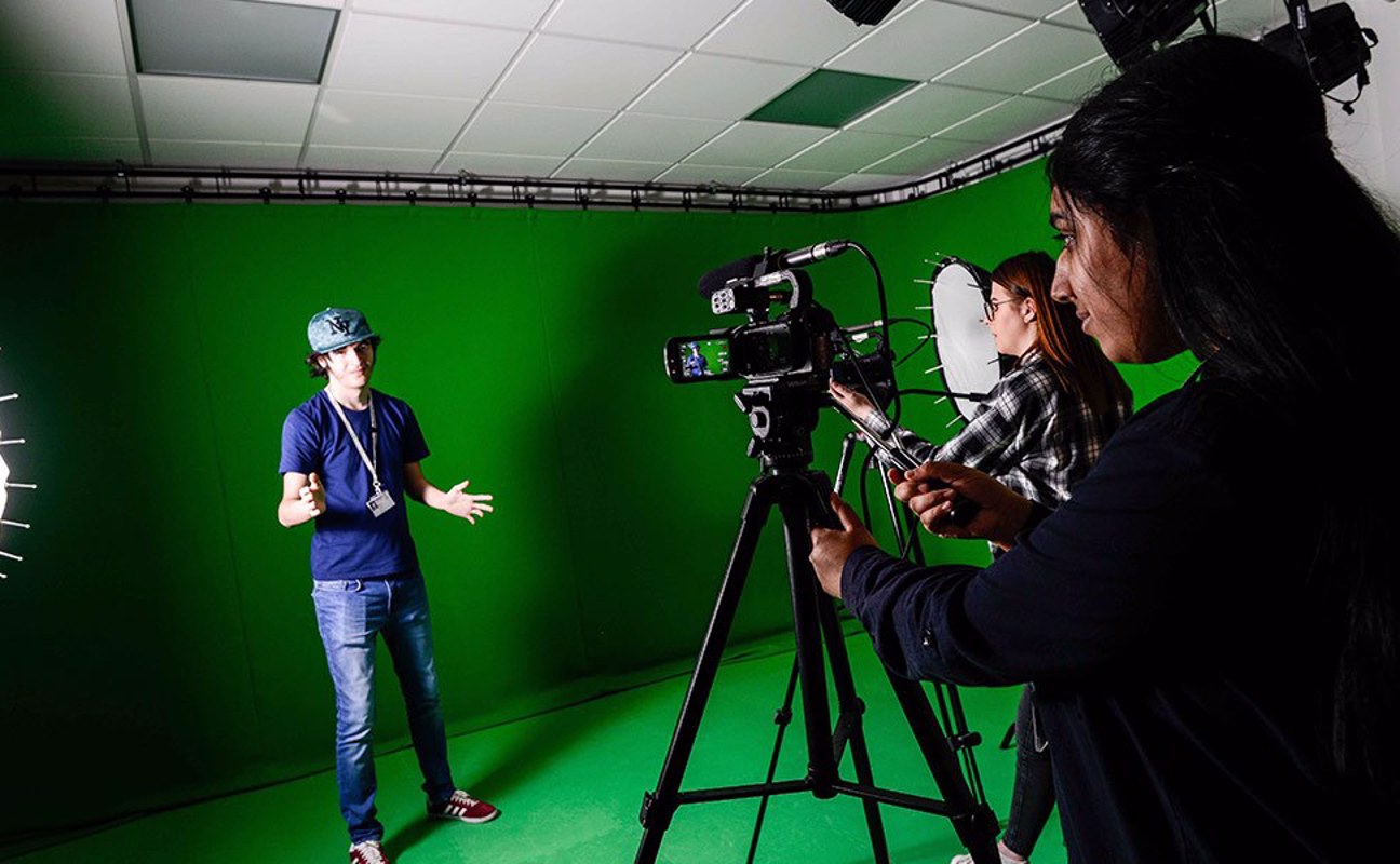 Students filming in front of a green screen