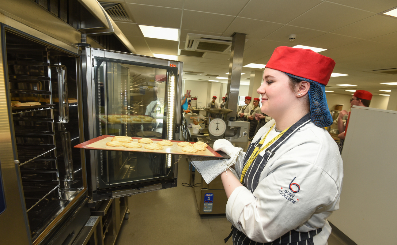 catering student putting things into the oven