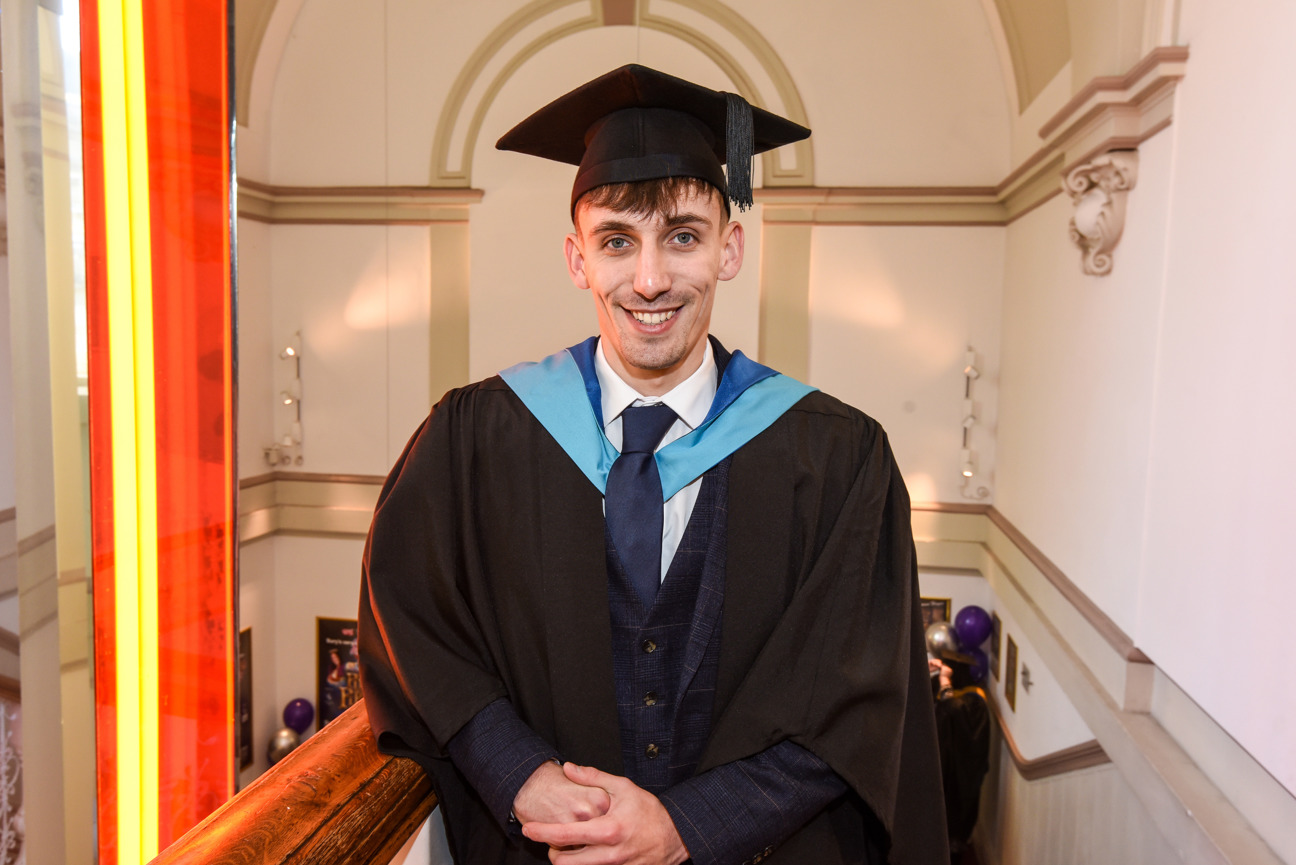 student stood on staircase at the met theatre on graduation day
