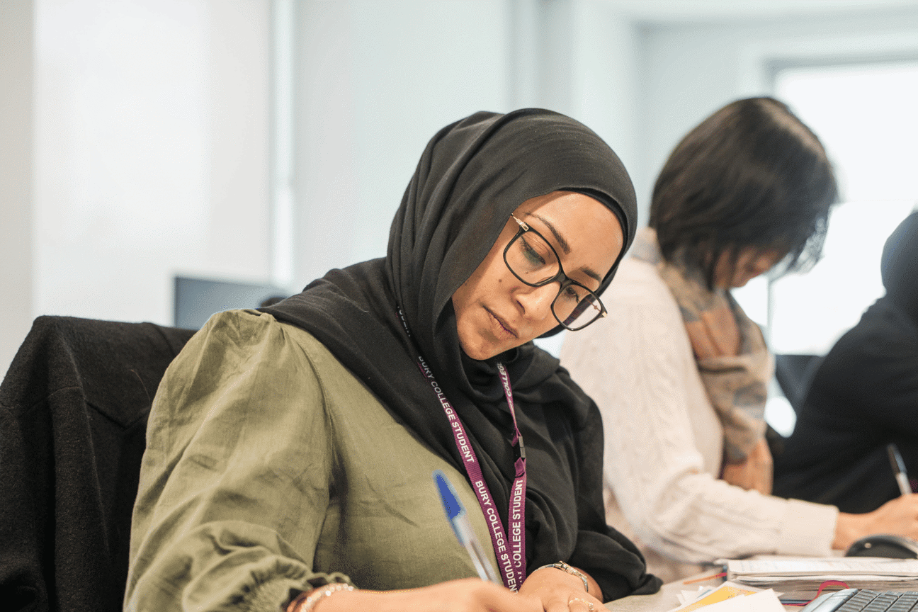 Adult learner writing in class