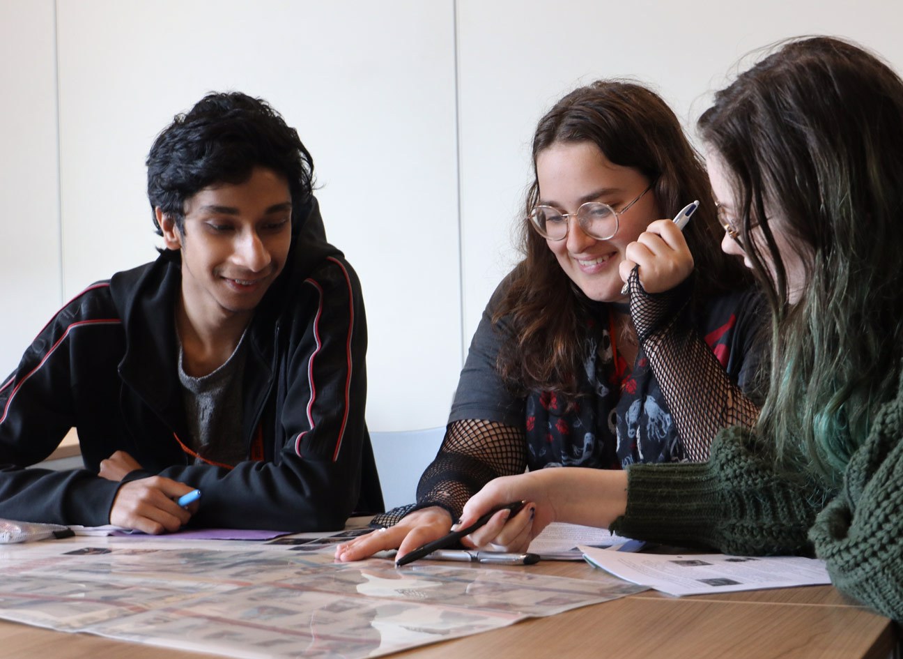Three students studying a History document
