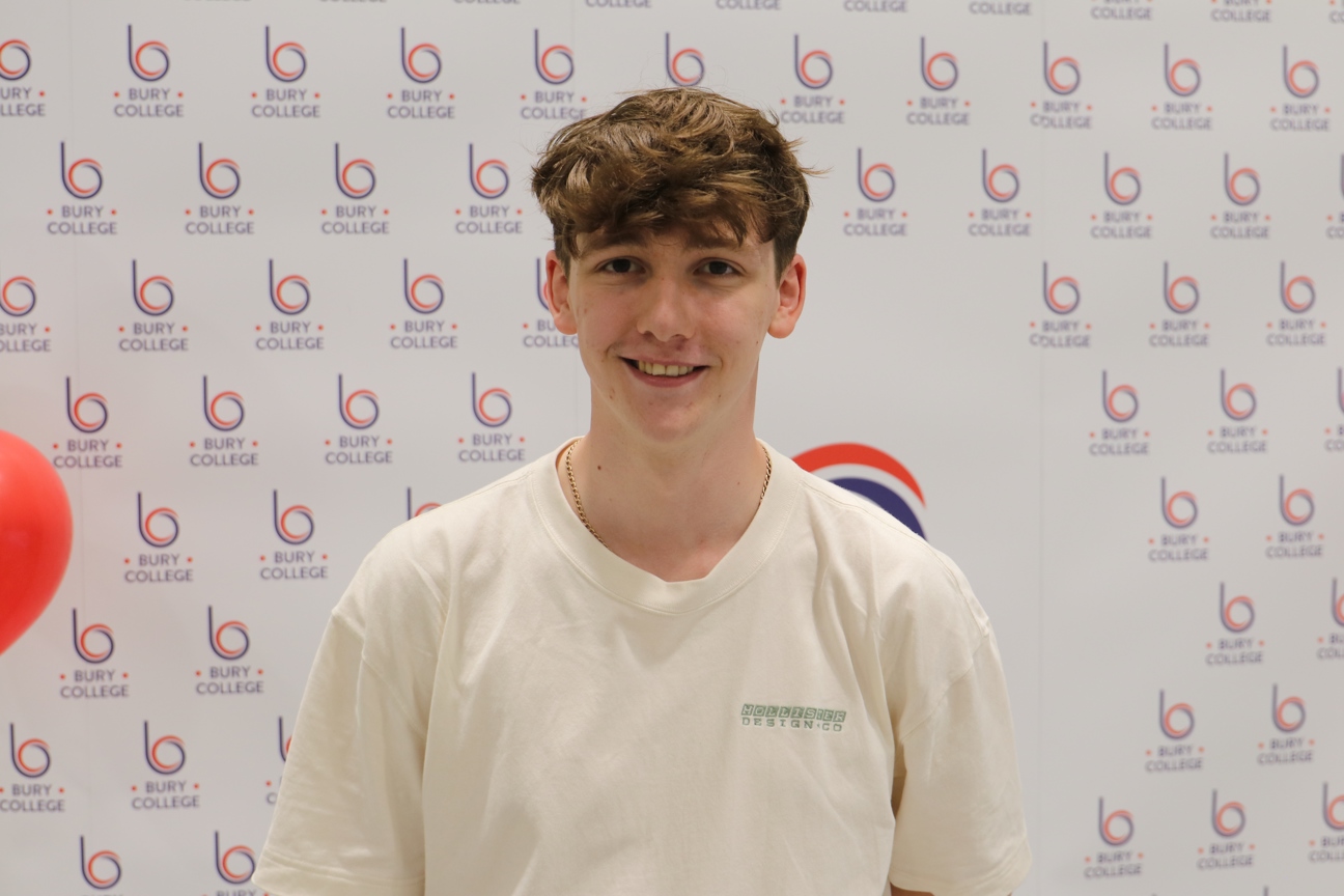 student smiling against Bury College backdrop