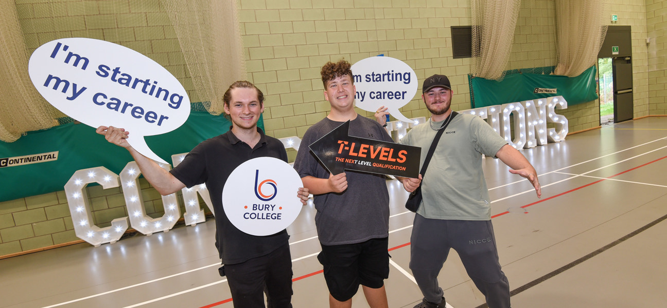 three students holding signs whilst celebrating on results day