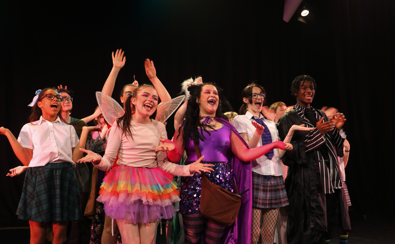 students stood in a row performing in a pantomime