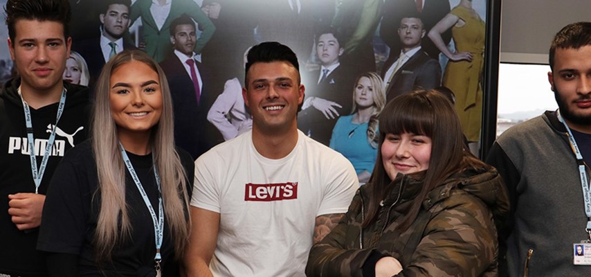 Former Bury College student, Lewis Ellis, stood with Business Studies students