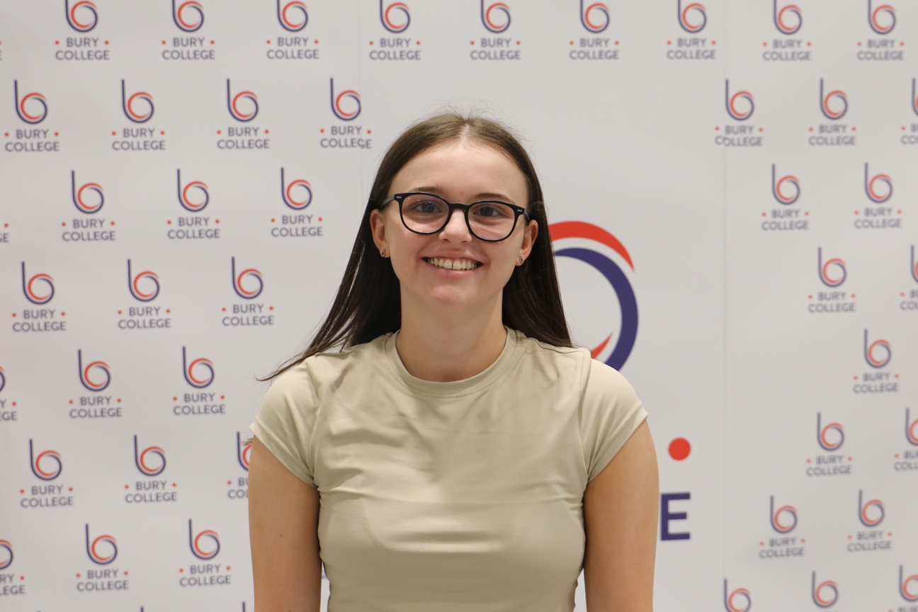 student smiling against Bury College backdrop