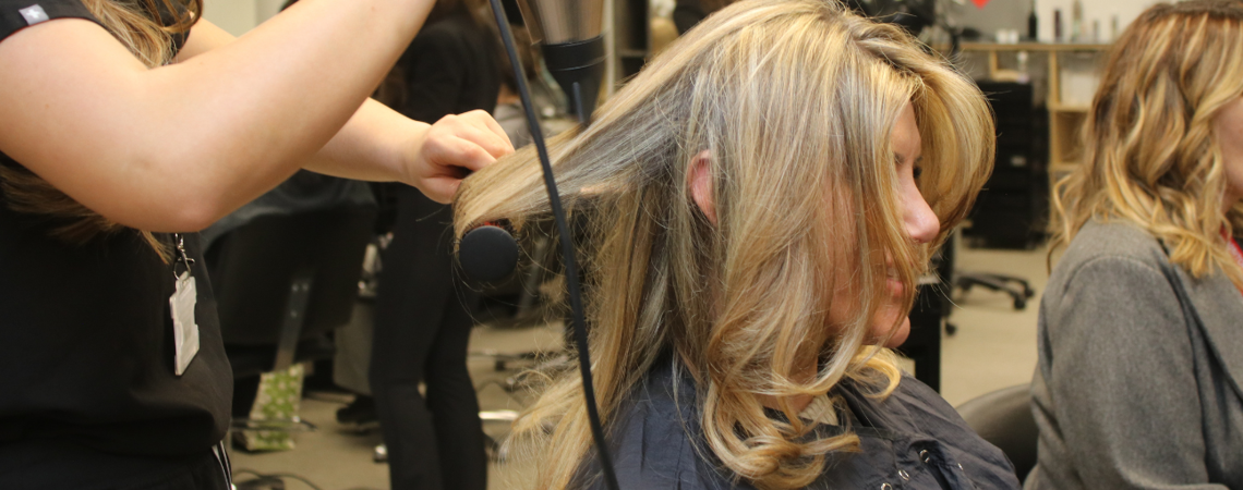 Apprentices blow-drying hair at charity event