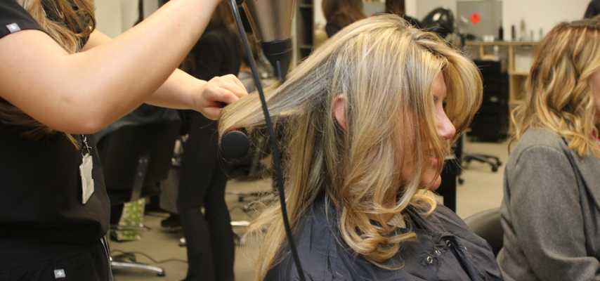 Apprentices blow-drying hair at charity event