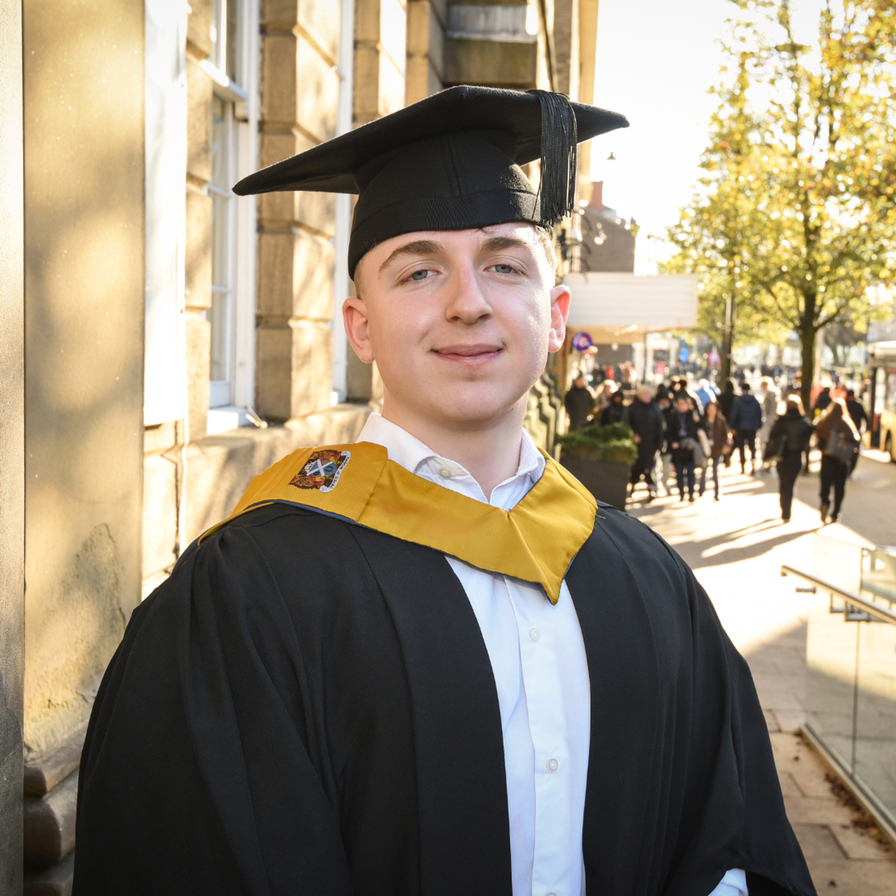 student stood proudly on their graduation day
