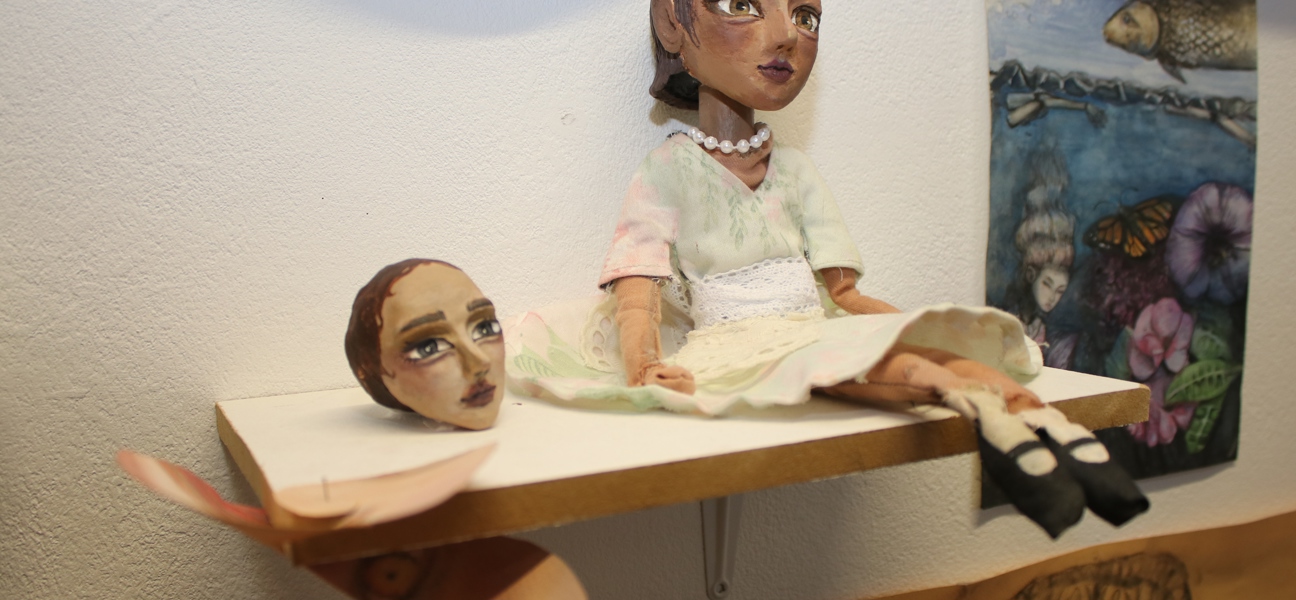 art of a doll on a shelf and dolls head