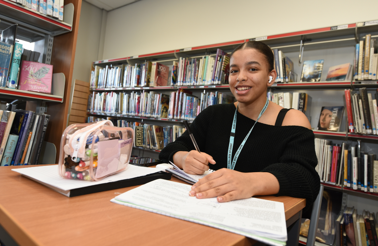 student sat in the library with an open book